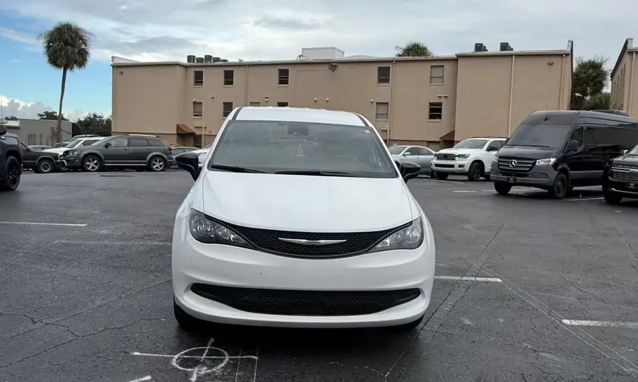 2025 Chrysler Voyager LX wheelchair accessible van Orlando, white front view parked in a lot with a beige building behind it