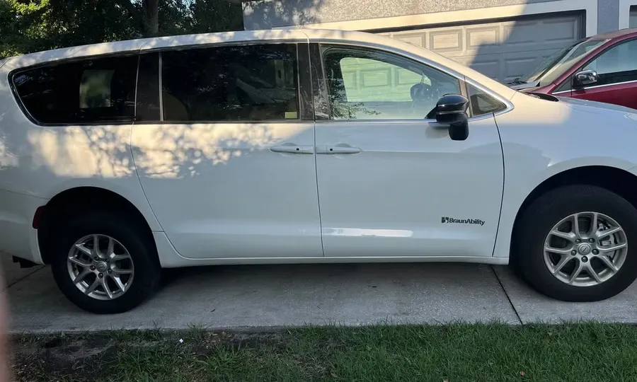 2025 Chrysler Voyager LX wheelchair accessible van Orlando, white passenger-side exterior view in a driveway