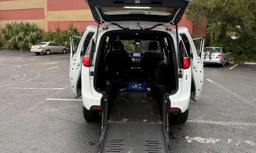 2025 Chrysler Voyager LX wheelchair accessible van Orlando, white rear view with the rear hatch and sliding doors open and the BraunAbility ramp deployed