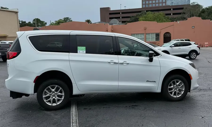 2025 Chrysler Voyager LX wheelchair accessible van Orlando, white exterior side view showing the loading-space reminder decal on the window